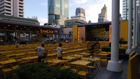 The Singha Beer Park outside CentralWorld mall.  Yellow tables, thousands of yellow chairs, and large stage in center-right of pic.