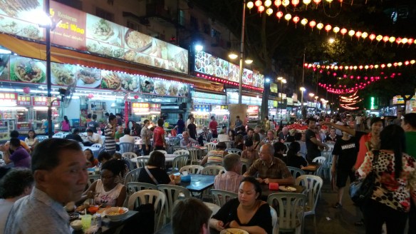 Typical street hawker food stand, with tables/chairs set up in the street.