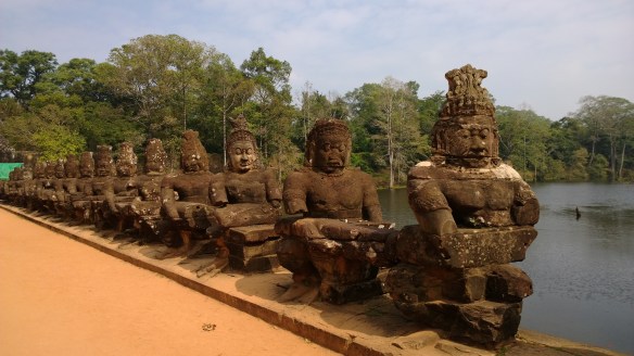 Stone carvings on bridge leading to the Angkor complex of temples.