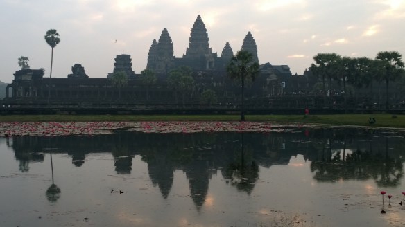 The stunning Angkor Wat temple at sunrise, reflected in a pond in front of the temple.  
