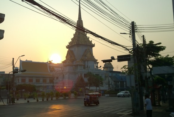 Wat Traimit (Temple of the Golden Buddha) at sunrise, with a tuk yuk cruising by